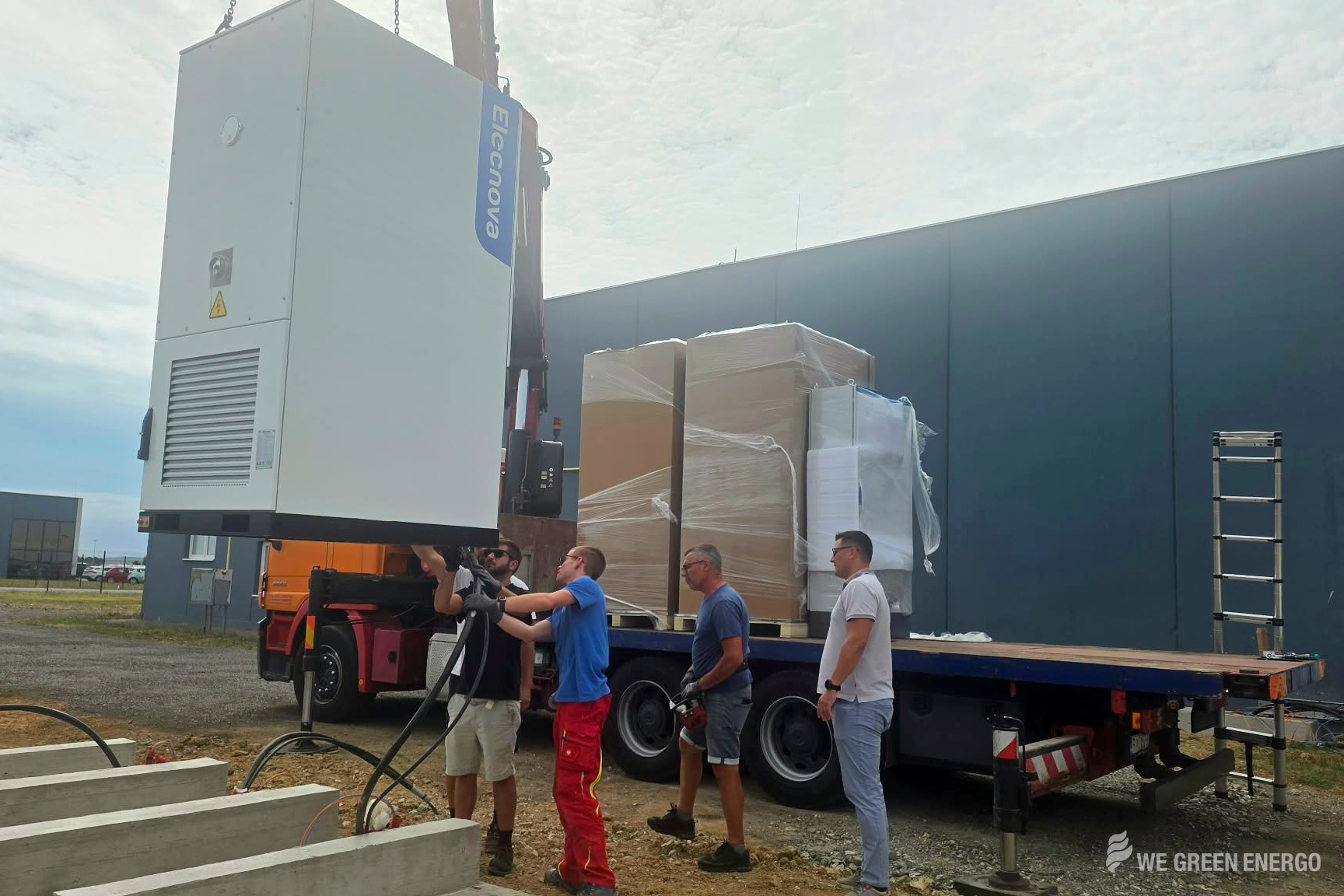 Mitglieder des Caelus-Teams entladen einen Schaltschrank von einem Lkw.